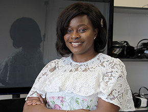 Lady smiles widely with arms folded